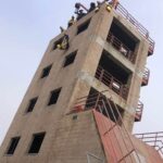 Firefighters rope slide from a tower