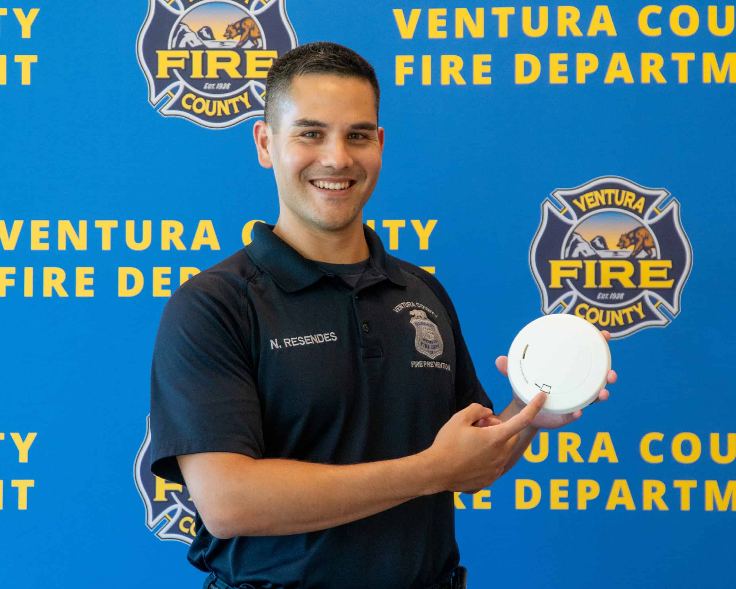 Fire Prevention employee holding a Smoke Alarm